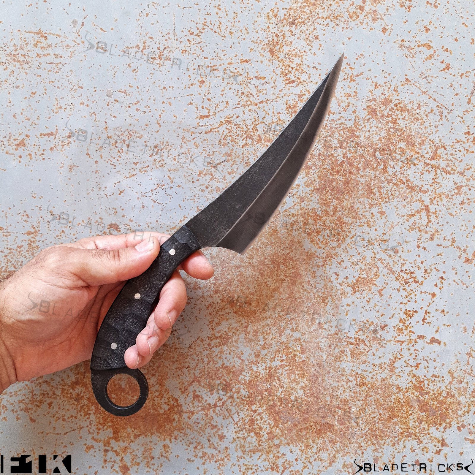 Hand holding the Bladetricks F1K black G10 karambit in forward grip
